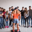 A group of people admiring a bodybuilder